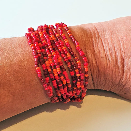Ninky Designs Australia stretch seed bead bracelets in shades of red worn on a wrist as a stackable set