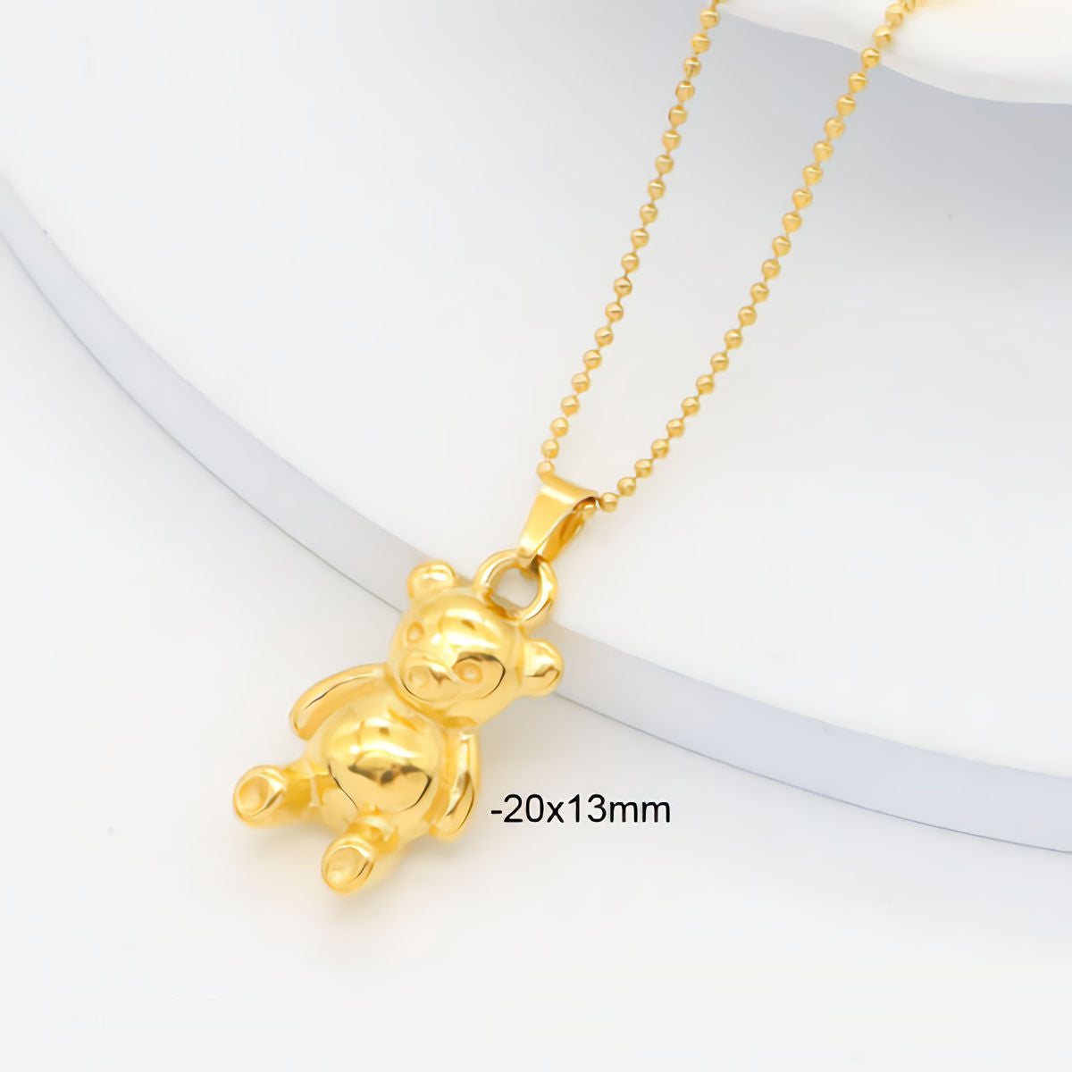 Gold teddy bear pendant on a chain with dimensions displayed