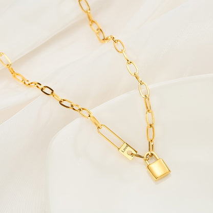 Gold chain bracelet with a lock charm on a light beige background