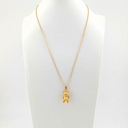 Gold necklace with a teddy bear pendant on a mannequin bust against a white background
