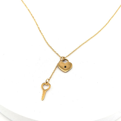A delicate gold necklace featuring a small heart-shaped padlock and a matching heart-shaped key pendant, displayed on a clean white background.