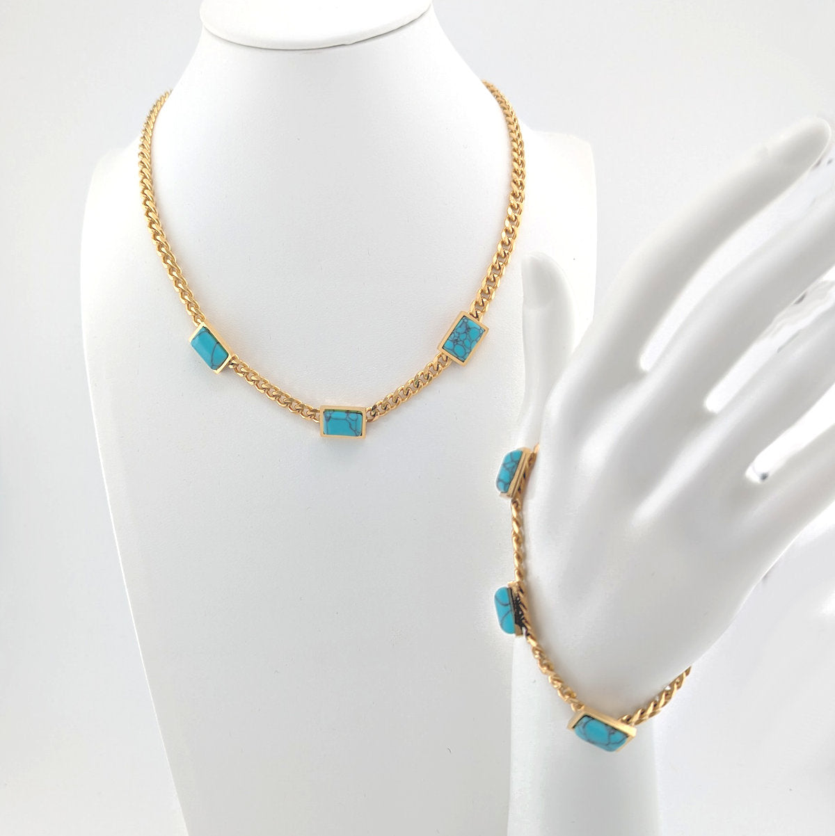 Gold necklace with turquoise stones on a mannequin bust.