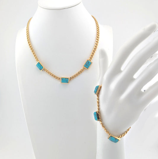 Gold necklace with turquoise stones on a mannequin bust.