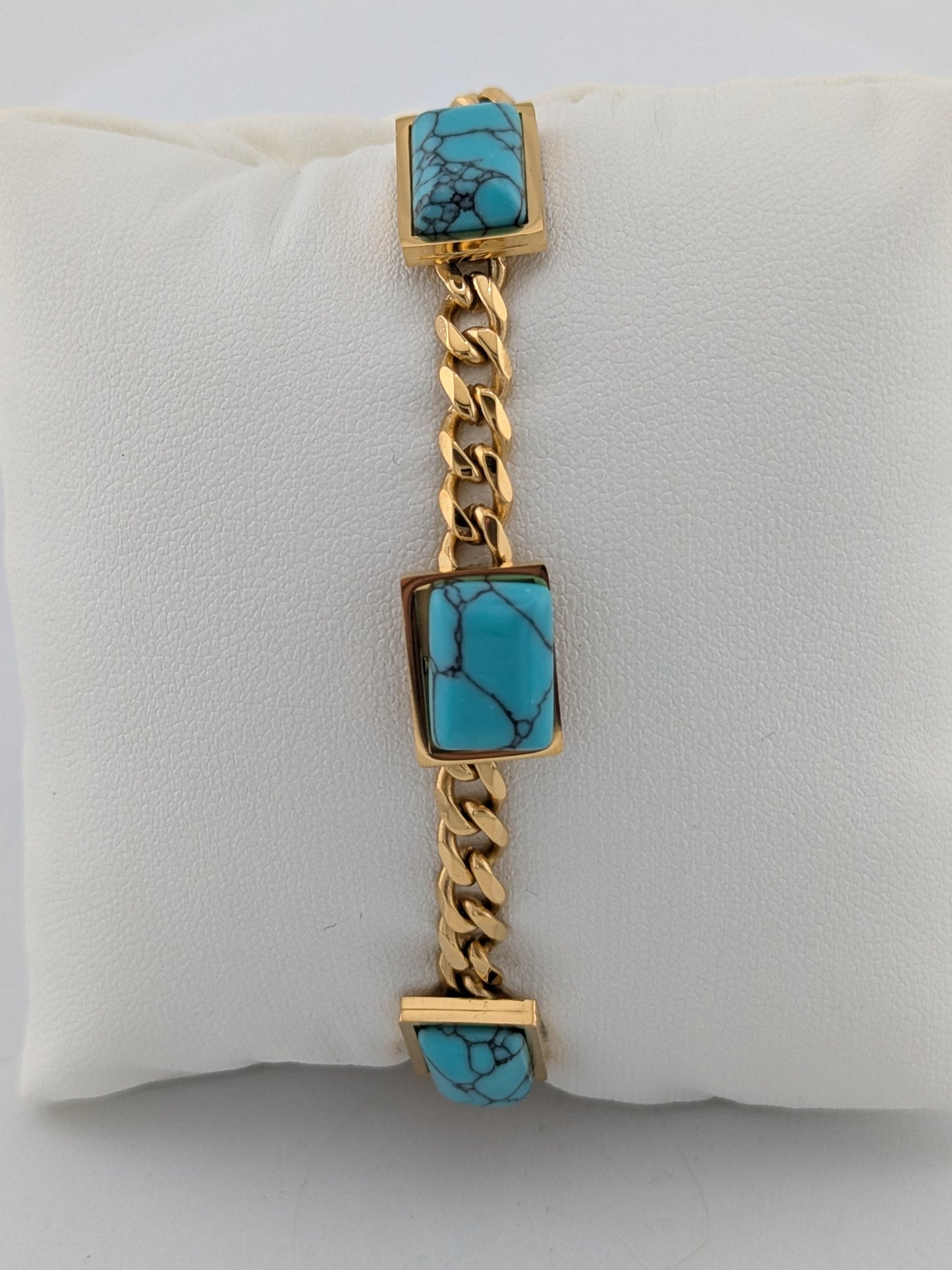 Ninky Designs Gold chain bracelet with turquoise stones on a white cushion