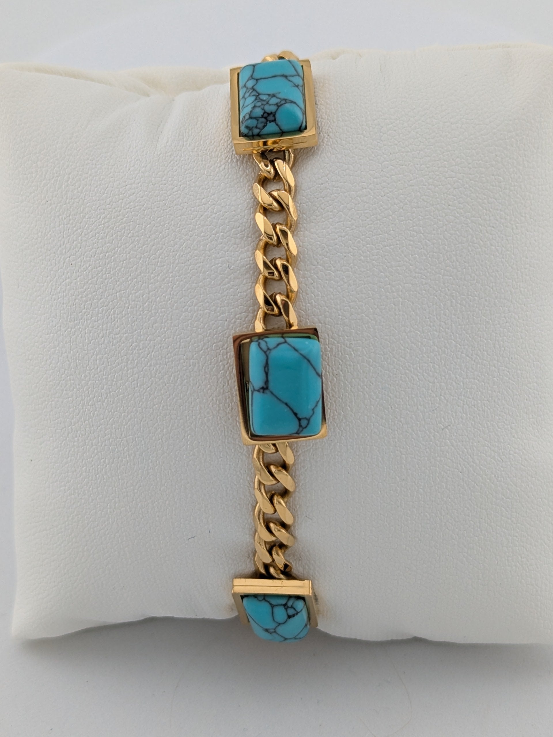 Ninky Designs Gold chain bracelet with turquoise stones on a white cushion