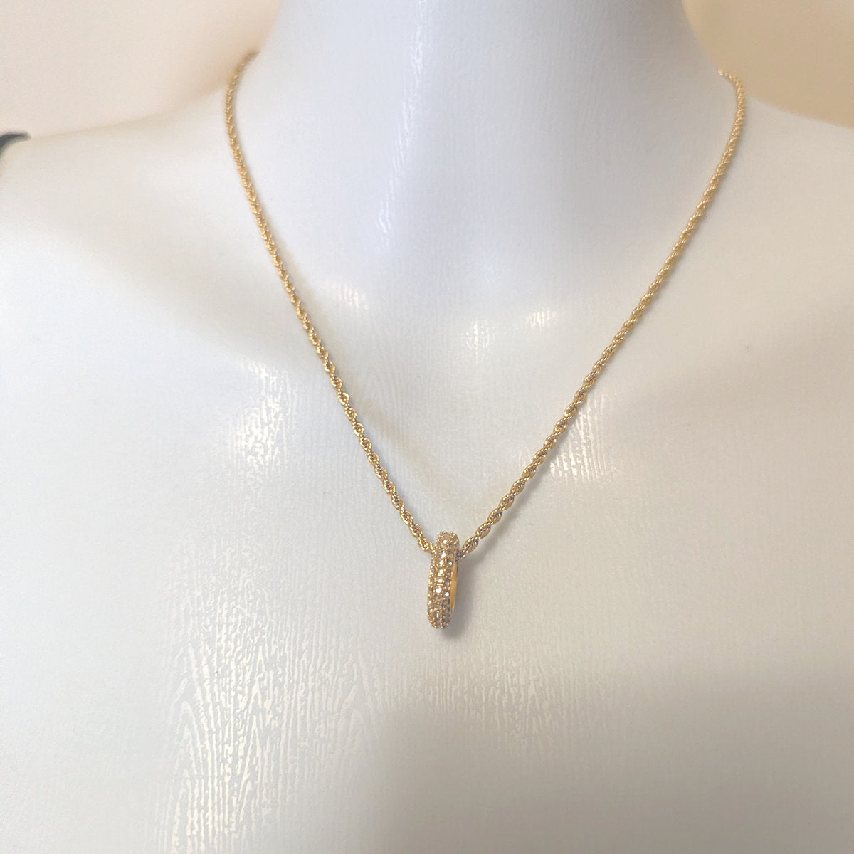 Gold necklace with a pendant on a mannequin