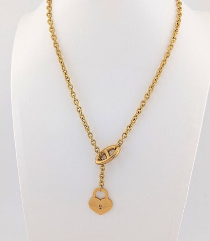 This 18K Gold plated, Stainless Steel chain necklace features a distinctive toggle closure and a heart-shaped padlock pendant