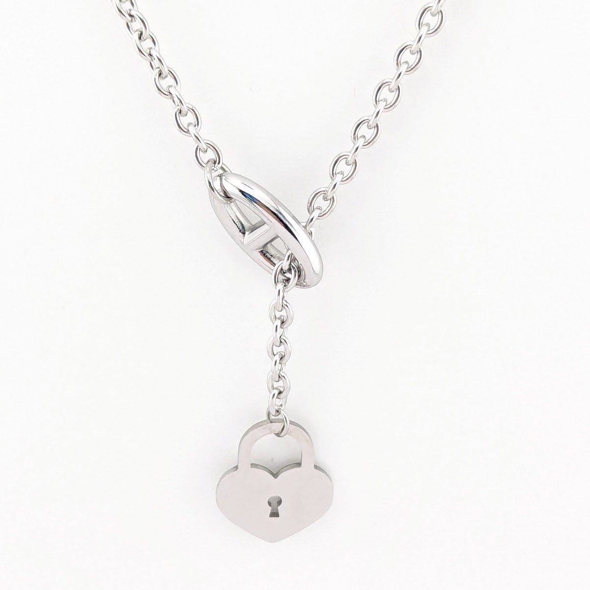 This 18K Gold plated, Stainless Steel chain necklace features a distinctive toggle closure and a heart-shaped padlock pendant